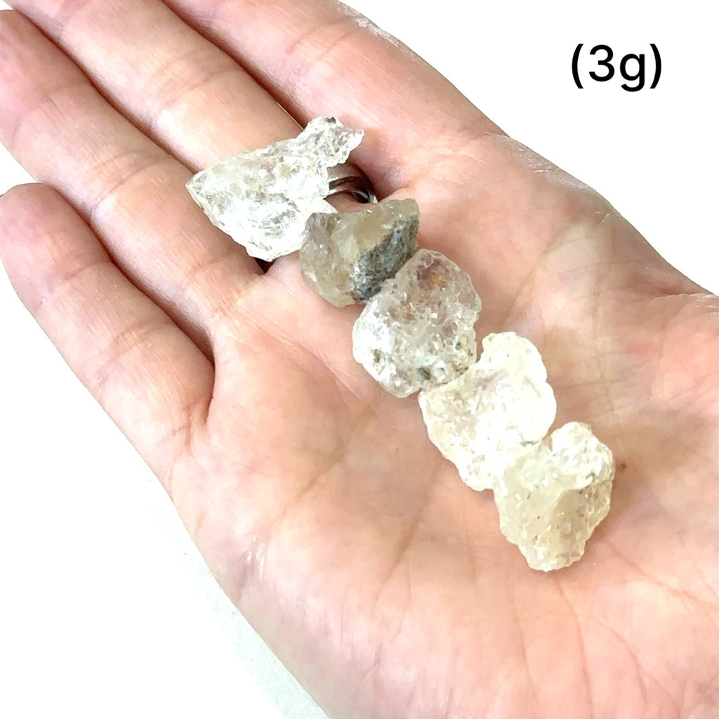Healing Hyalite Opal crystal for intuition, serenity, and inner peace grouping of (3g) on white in hand for overview
