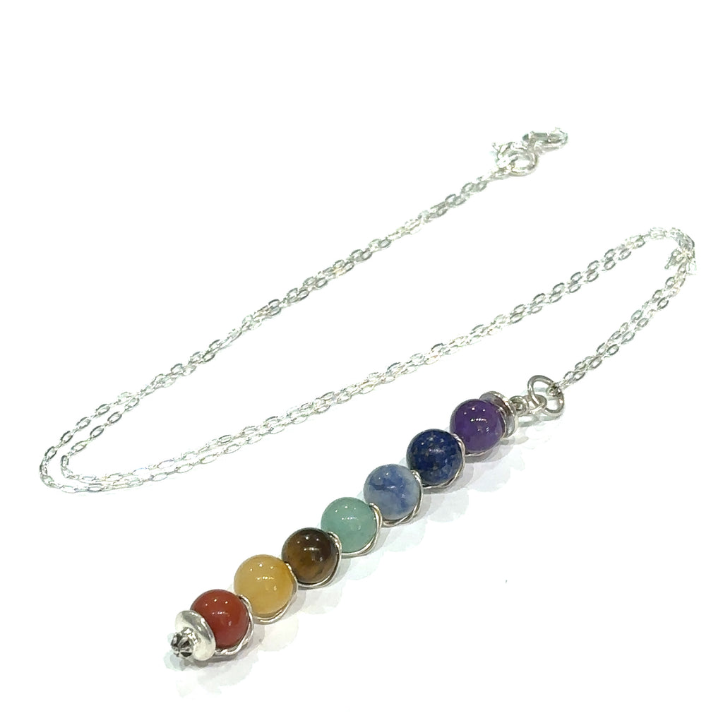 Healing jewelry featuring seven chakra stones on 18 inch silver chain on white center overview