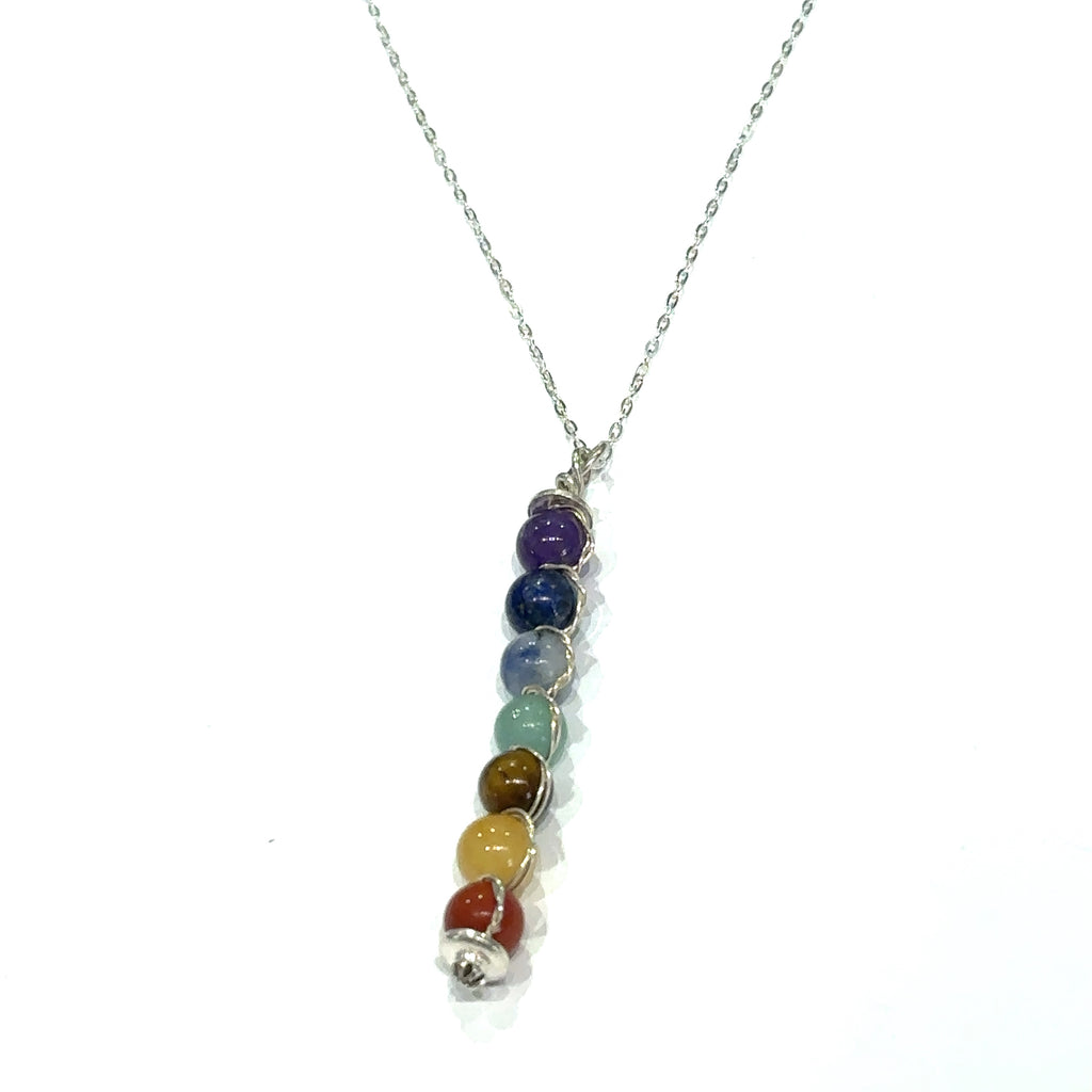 Healing jewelry featuring seven chakra stones on 18 inch silver chain on white hanging front overview