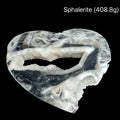 Heart-shaped sphalerite crystal on a black background with weight indication #A (408.8), front view.
