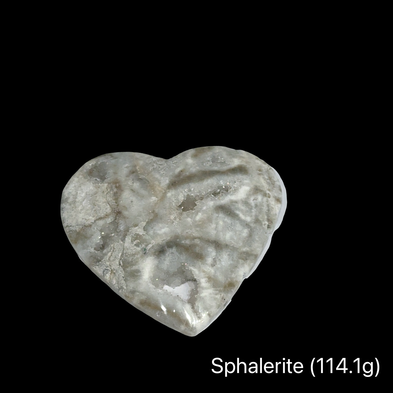 Heart-shaped sphalerite crystal on a black background with weight indication #C (114.1), front view.