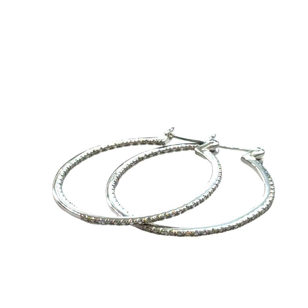 Inside-out diamond hoop earrings in sterling silver with snap-back closure showing sparkle, on a white background a close up front view. 