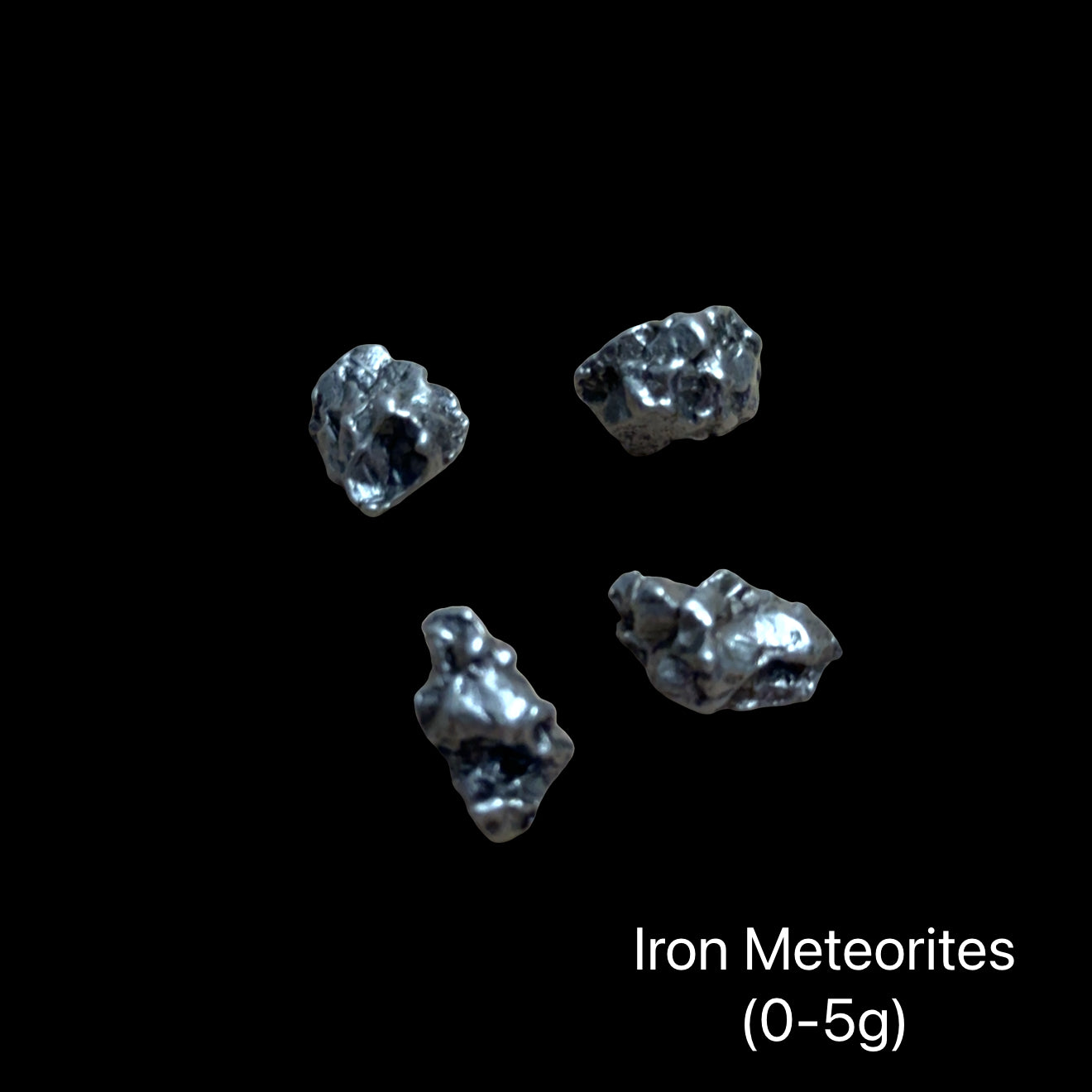 Iron meteorites on a black background with text indicating weight range (0-5g). front view.