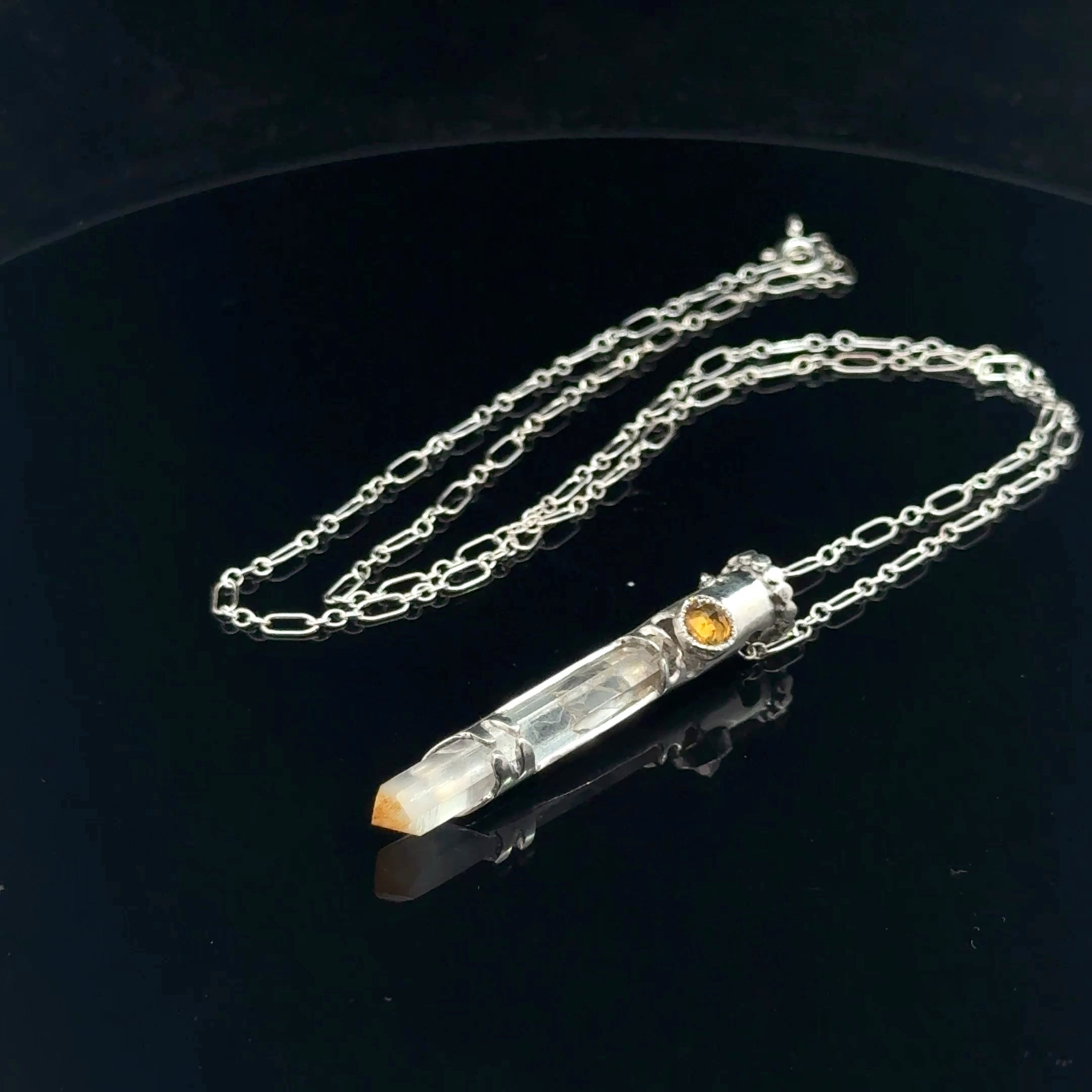 Mango Quartz Lightsaber Necklace in a Sterling Silver case with citrine gemstones to accent the pendant on a black background, front right angle view. 