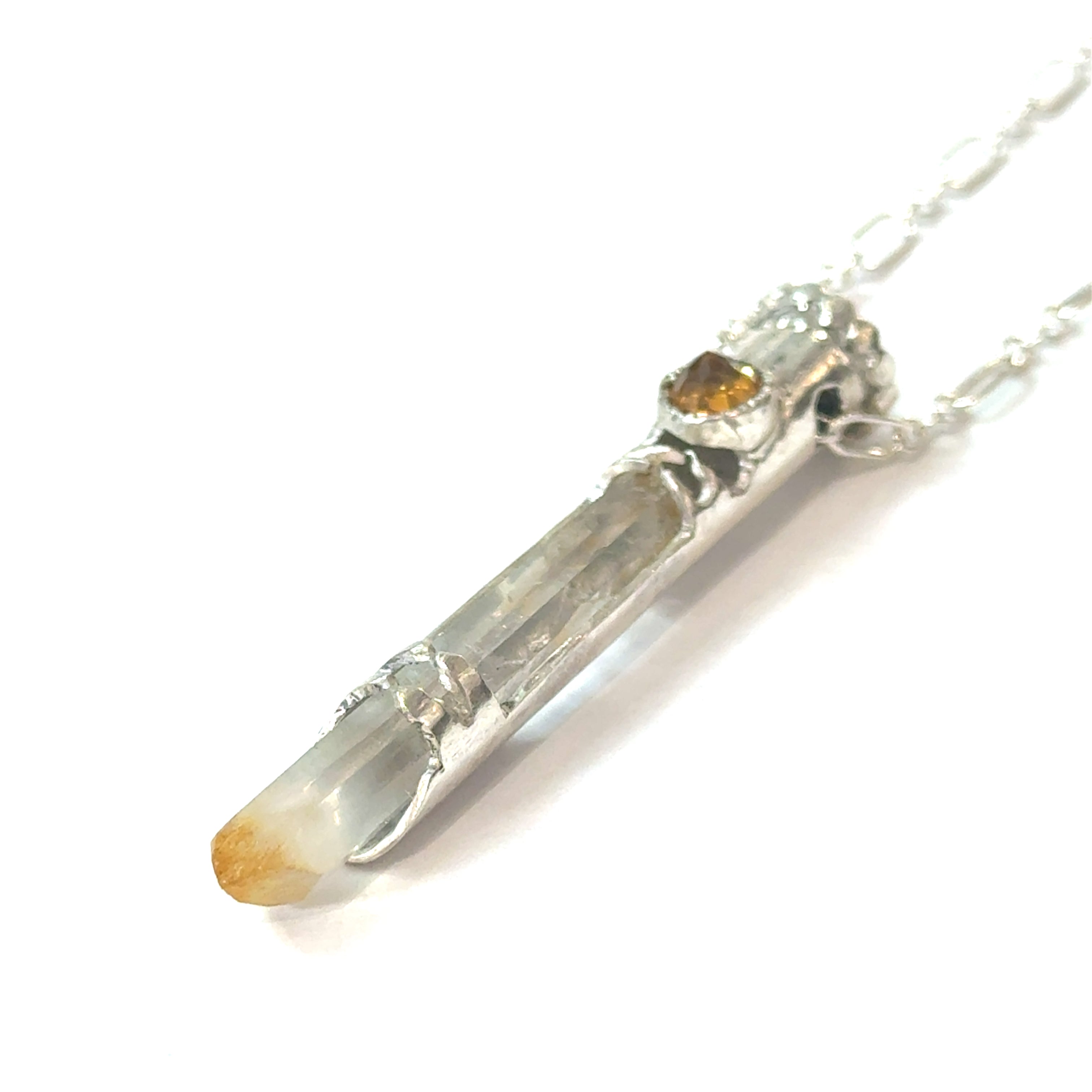 Mango Quartz Lightsaber Necklace in a Sterling Silver case with citrine gemstones to accent the pendant on a white background, in a models finger tips, front right angle view. 
