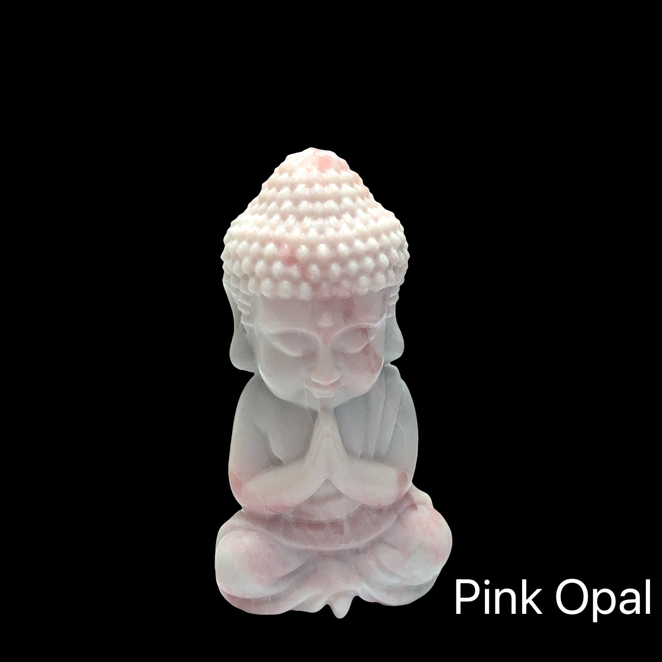 Medium pink opal Buddha statue with peachy-pink translucence and serene features, on a black background, in front view. 