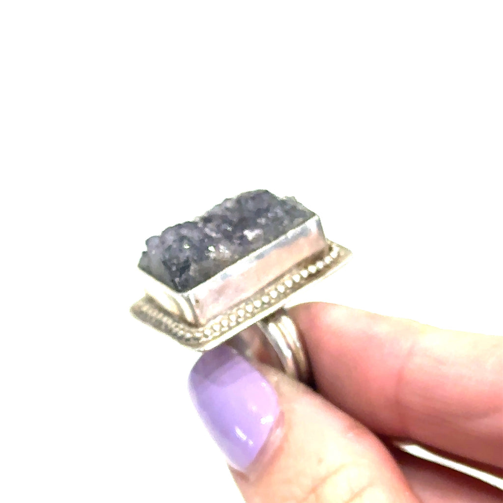 Model  holding Amethyst druzy gemstone ring with sterling silver band, reflecting spiritual elegance on white side view