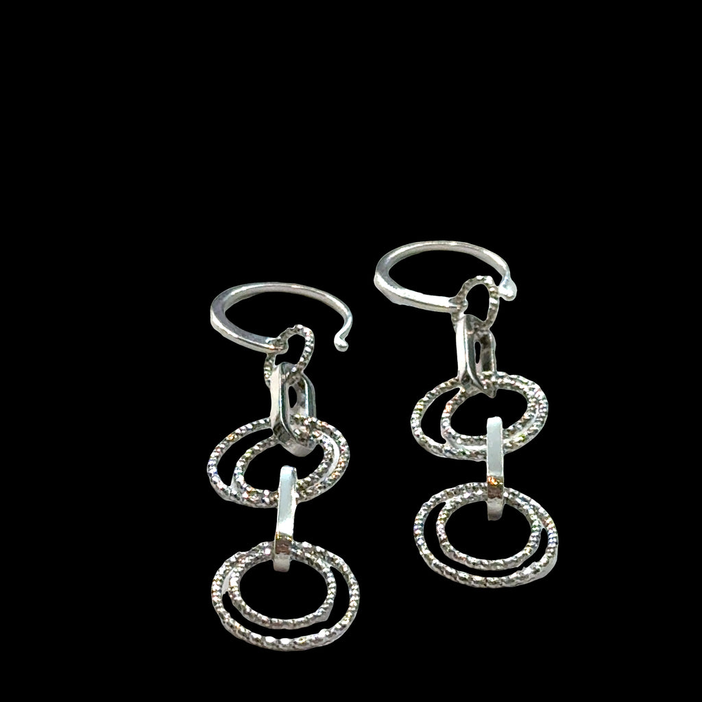 Multi-circle sterling silver dangle earrings with oval link showing sparkle and movement on a black background, front overview.