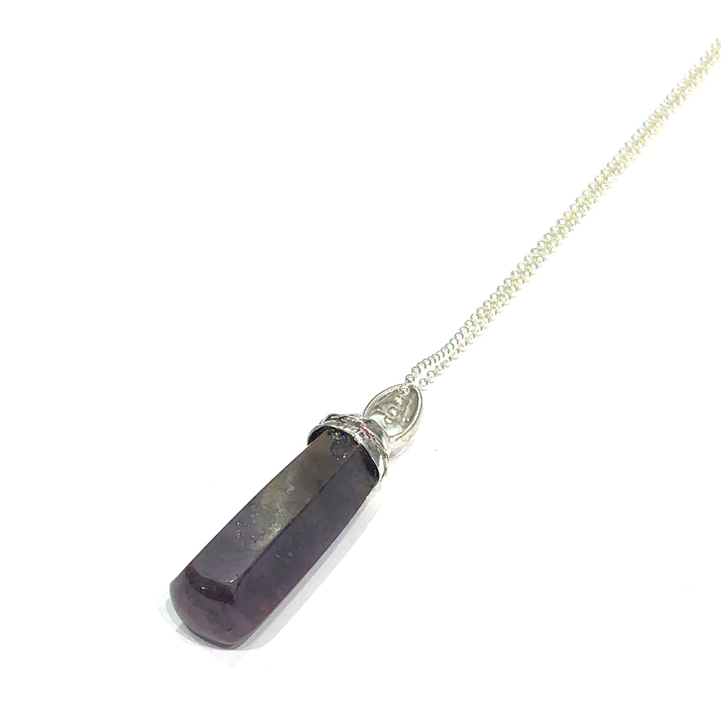 Natural ruby gemstone pendant with gem‑cut accent and swivel bail on white long angled view