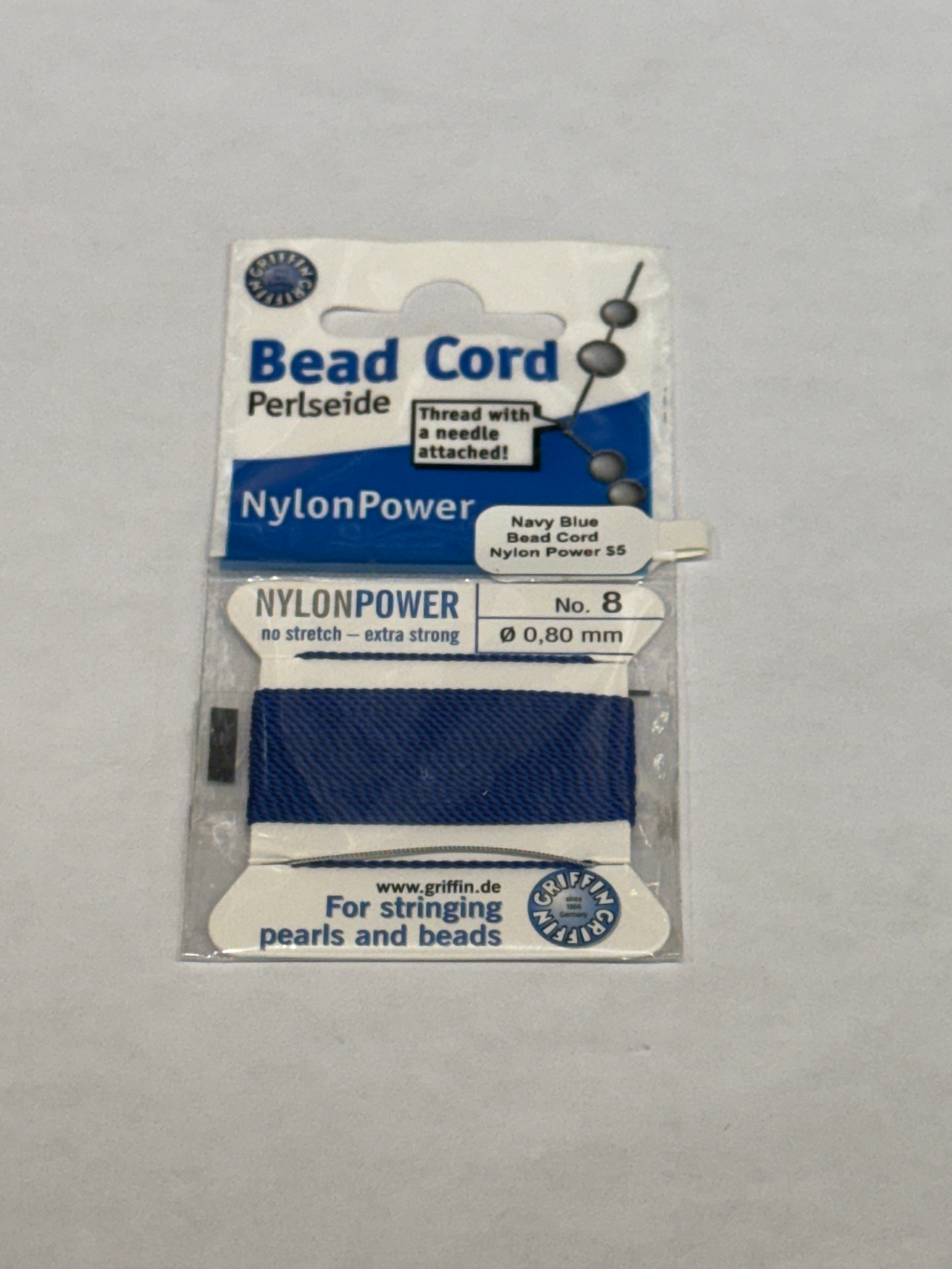 One package of Dark Blue Nylon Power Bead Cord  #8 on a white background, front view.