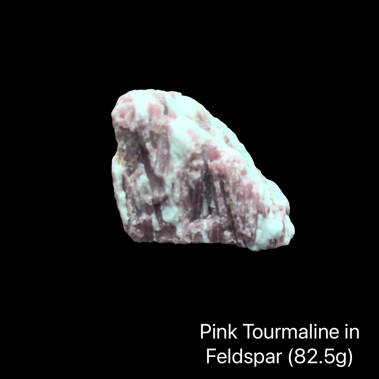 One piece of Rubellite Tourmaline in a Feldspar on a black background with weight indication (82.5), front view.