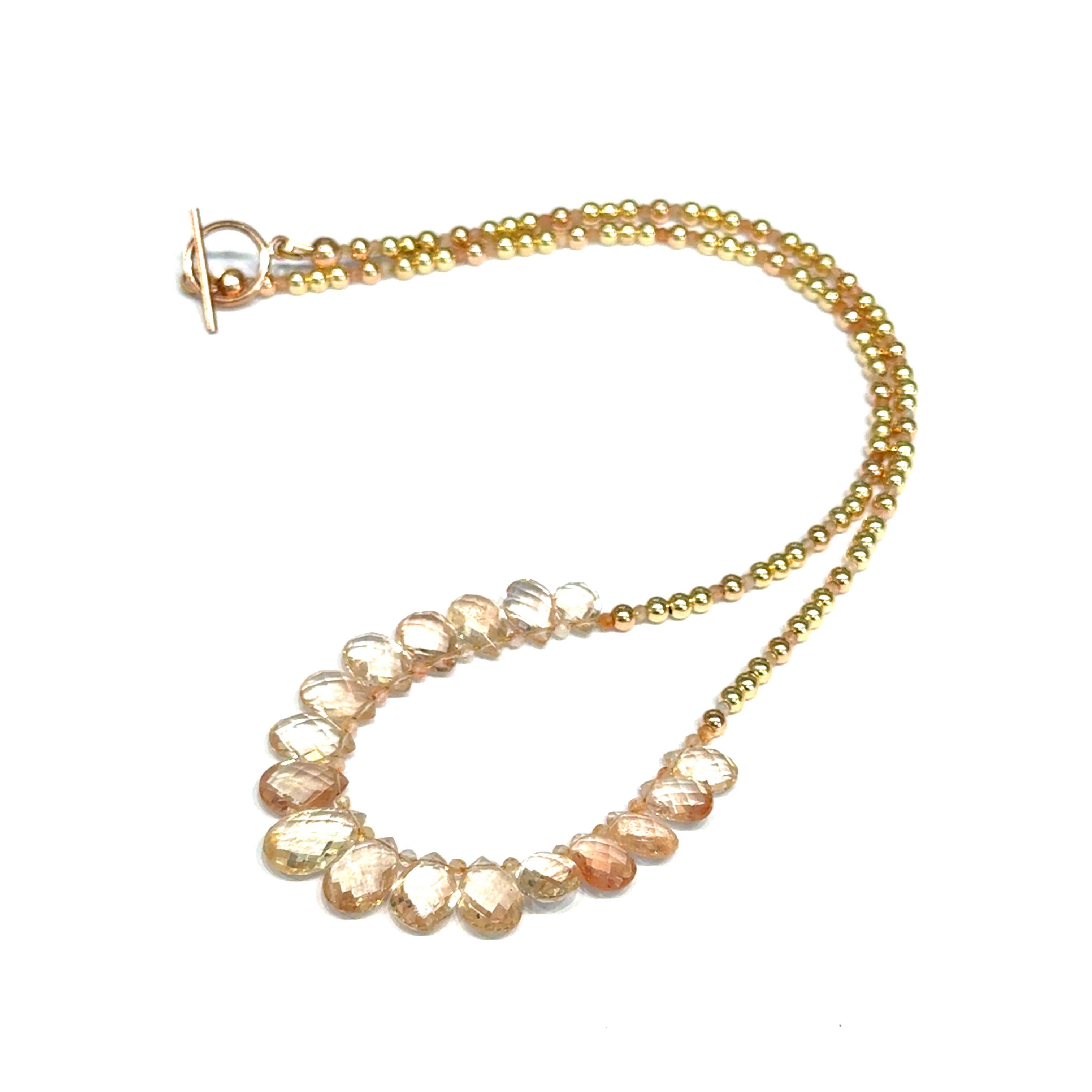 Oregon sunstone teardrop statement necklace with faceted focal stone and mixed metal sunstone beads showing peachy-copper brilliance on a white background, front close up view. 