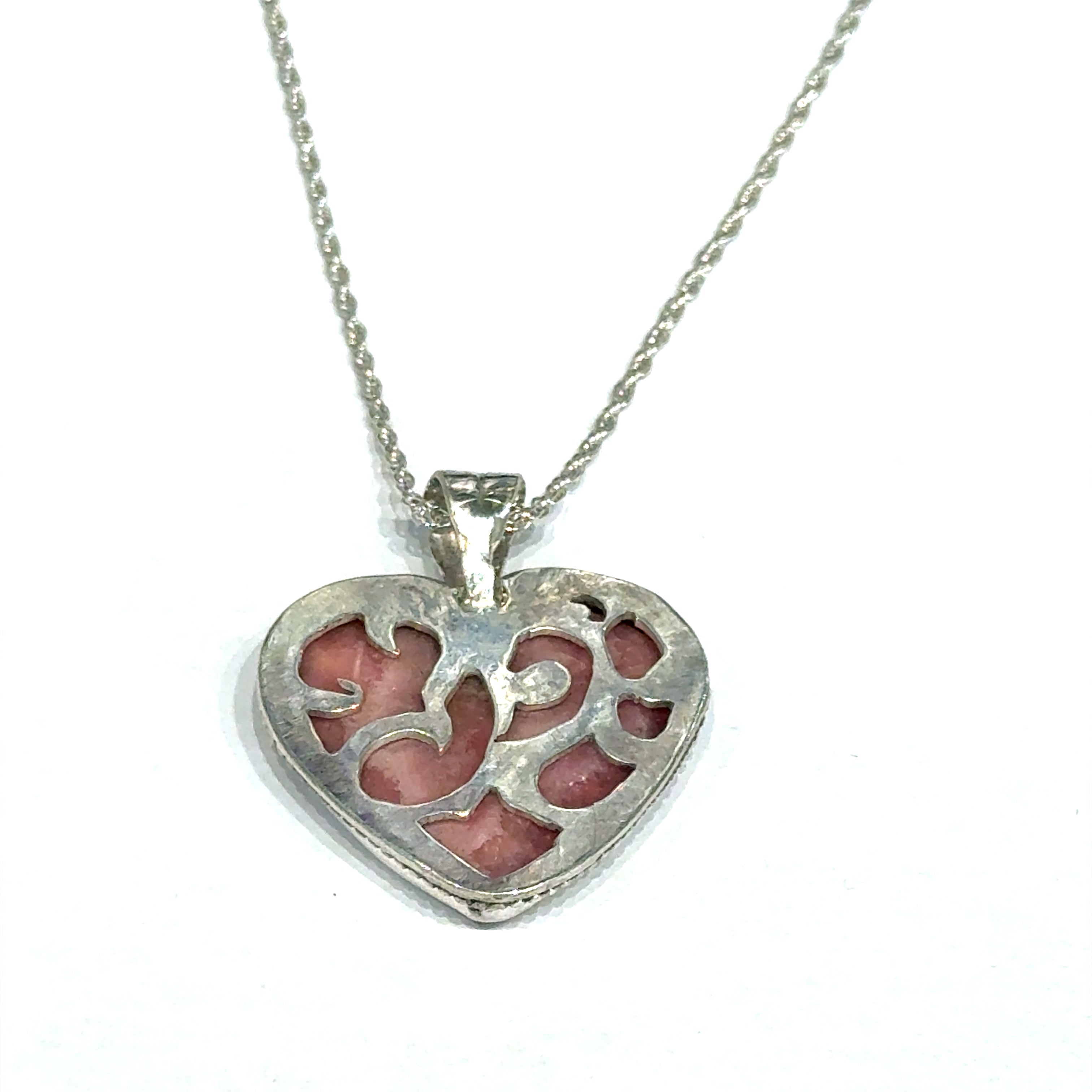 Pink Cobolto Calcite Heart-shaped gemstone pendant on a silver chain against a white background, back hung overview.