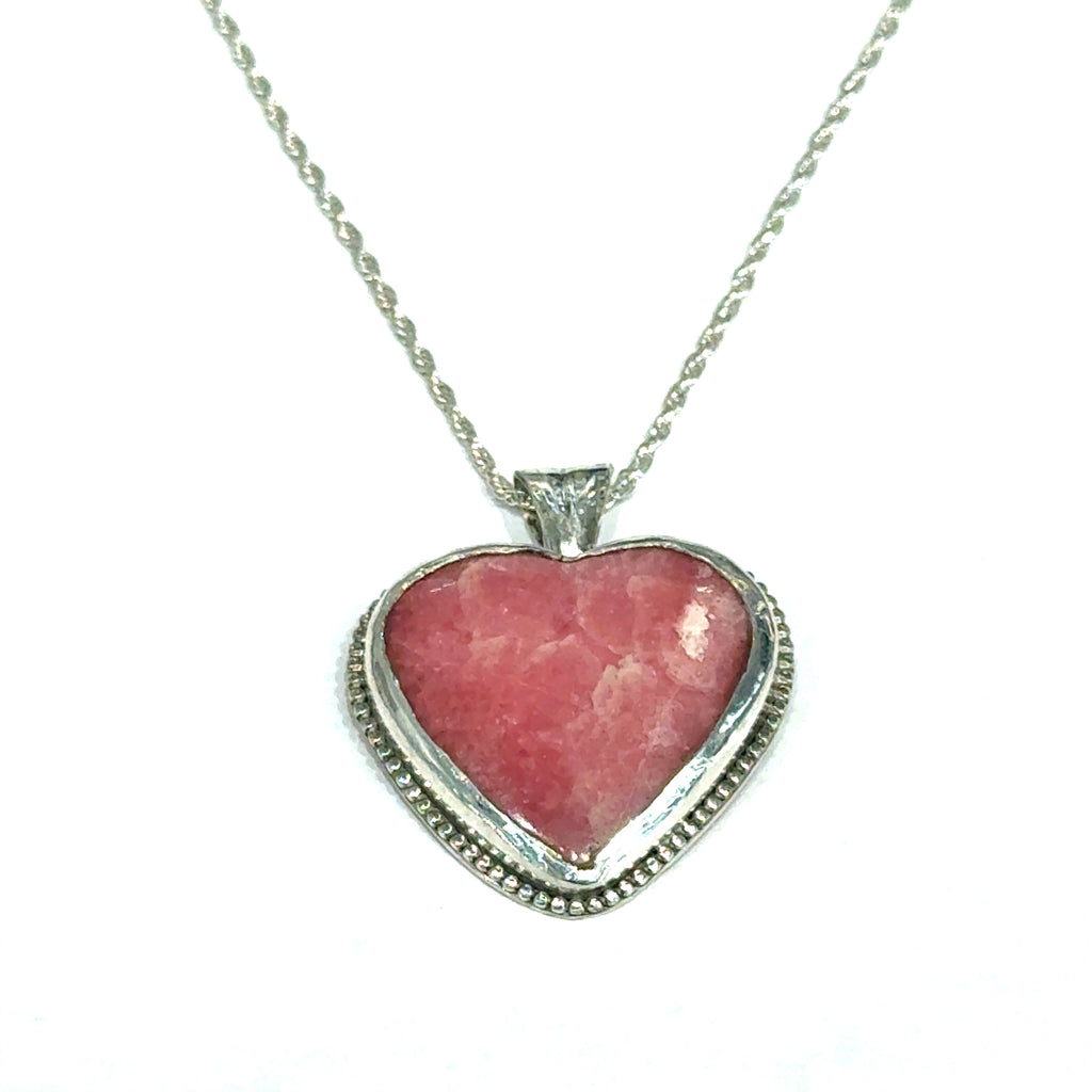 Pink Cobolto Calcite Heart-shaped gemstone pendant on a silver chain against a white background, front hung overview.