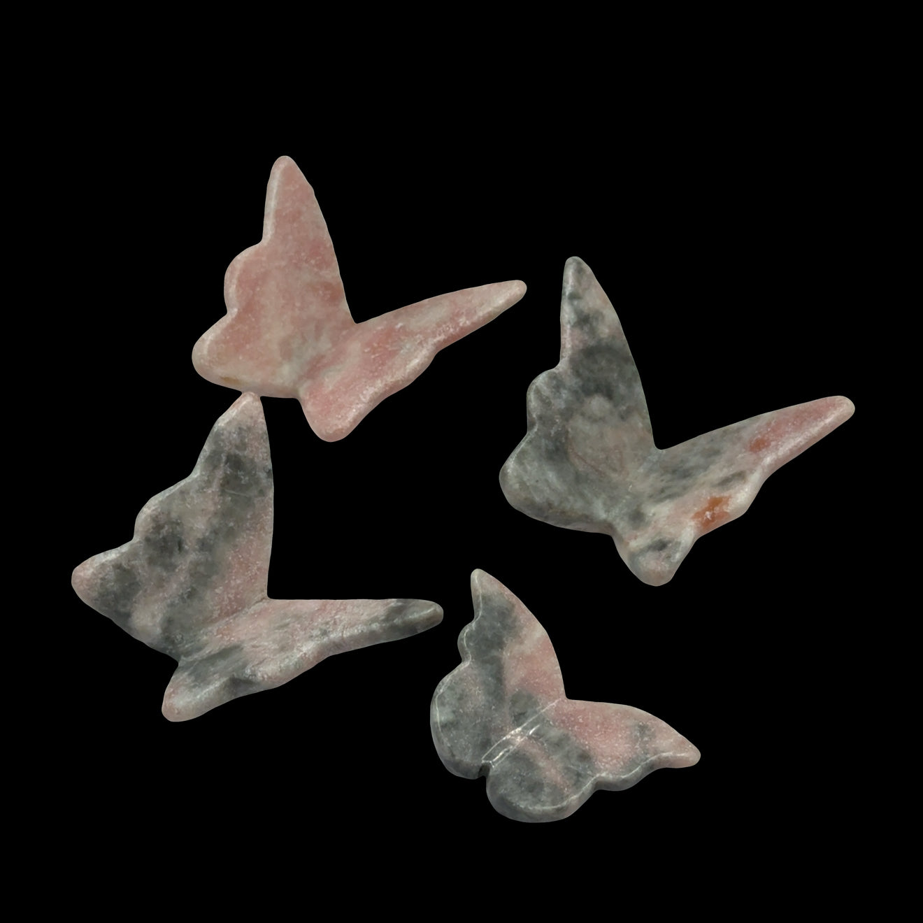 Pink Opal butterfly-shaped crystals on a black background, front view.