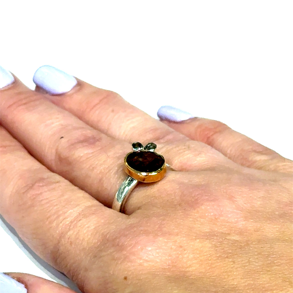 Pink sapphire and chocolate diamond mixed metal ring — handmade in Boston on a models hand flat on a white background front overview.