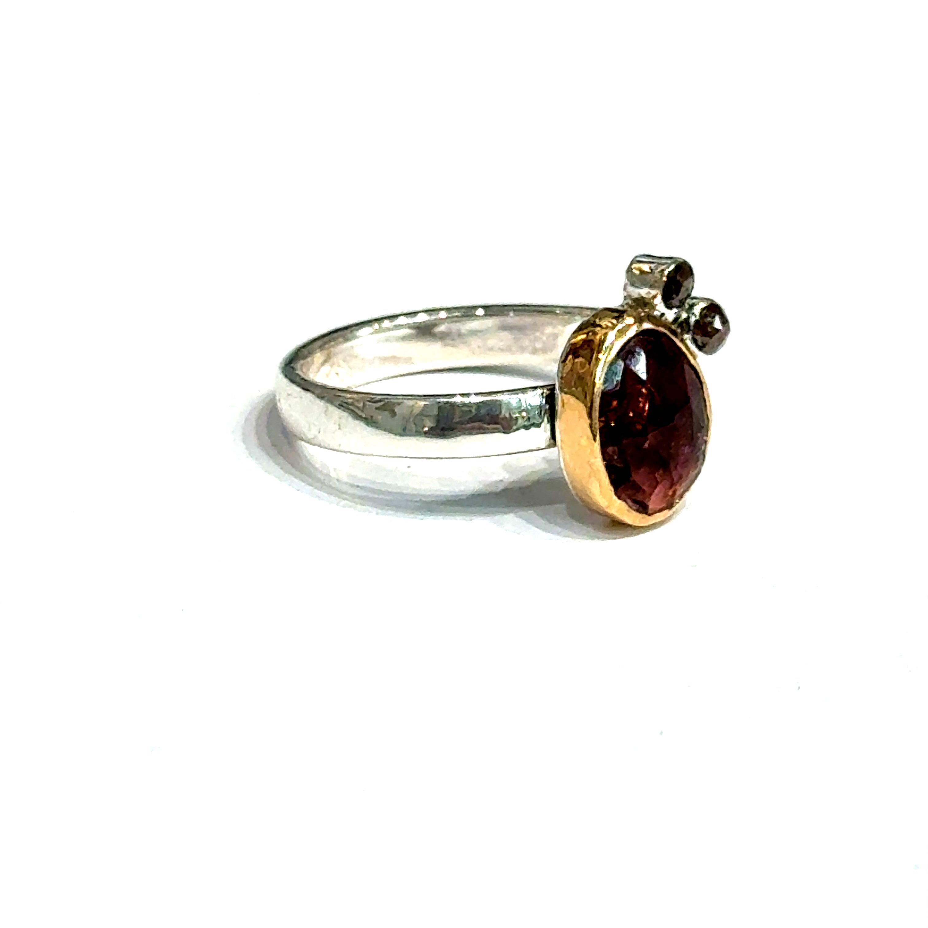 Pink sapphire and chocolate diamond mixed metal ring — handmade in Boston on a white background front right angle overview.