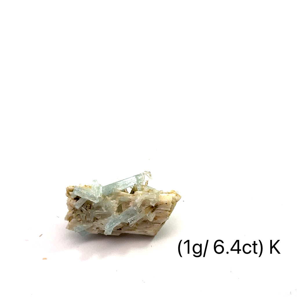 Raw Aquamarine with Schorl Gemstone 1g K on white close-up 
