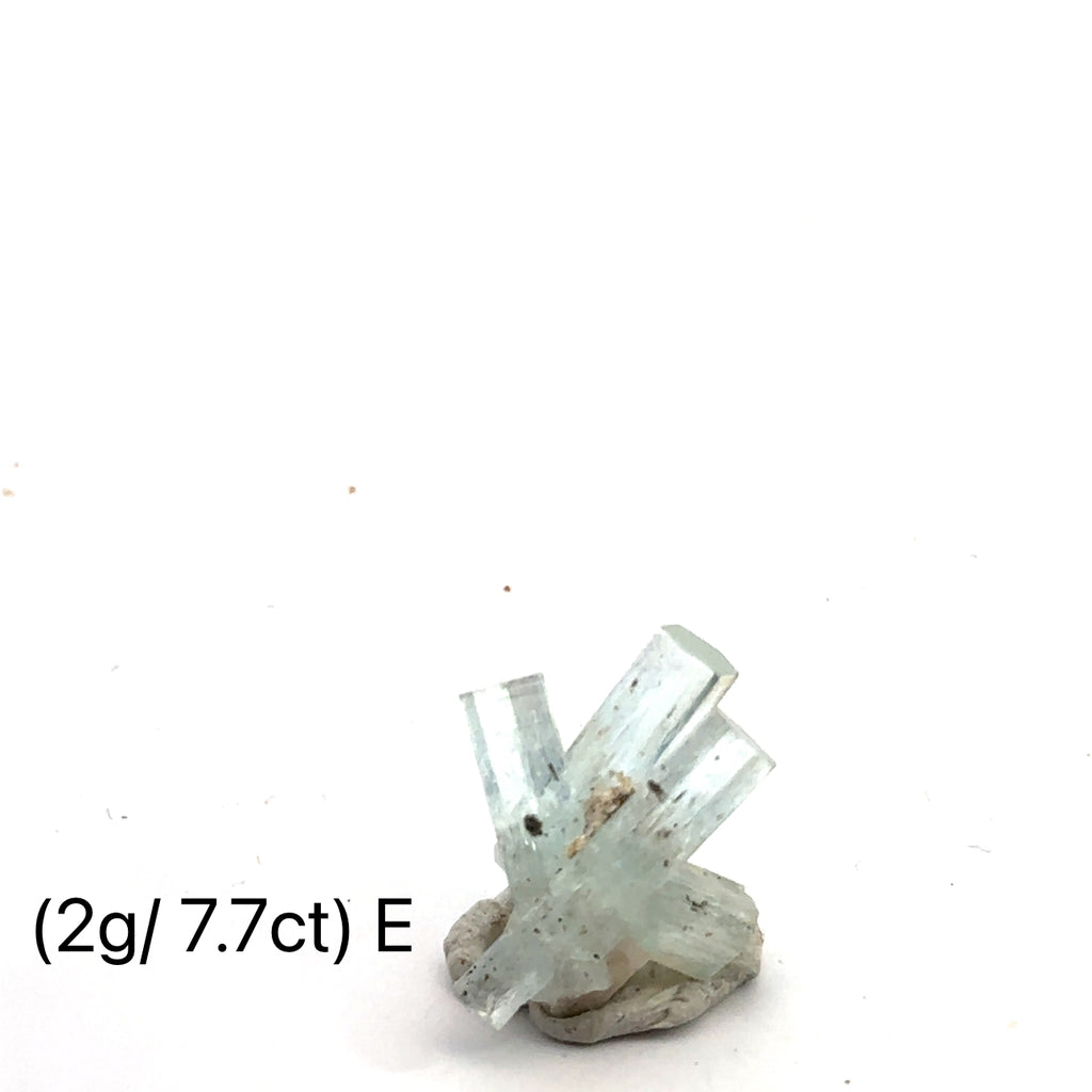 Raw Aquamarine with Schorl Gemstone 2g E on white close-up 