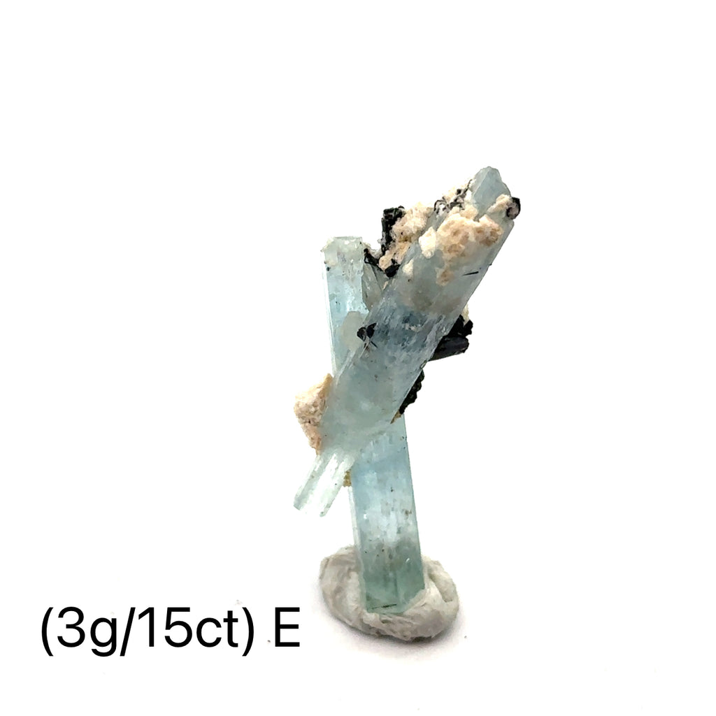 Raw Aquamarine with Schorl Gemstone 3g E on white close-up 