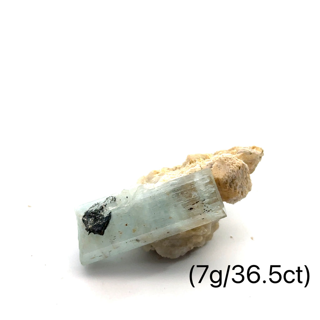 Raw Aquamarine with Schorl Gemstone 7g on white close-up