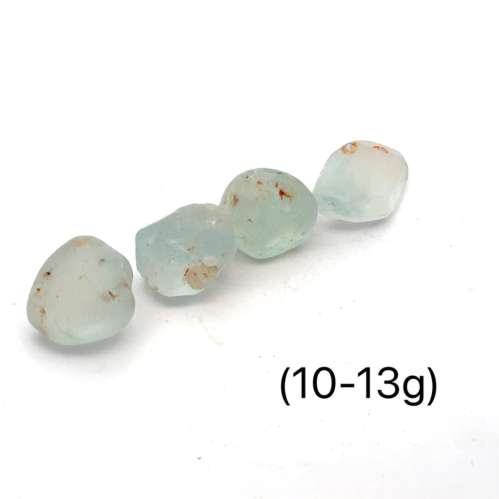 Raw Blue Topaz Gemstone on white grouping 10-13g front view 