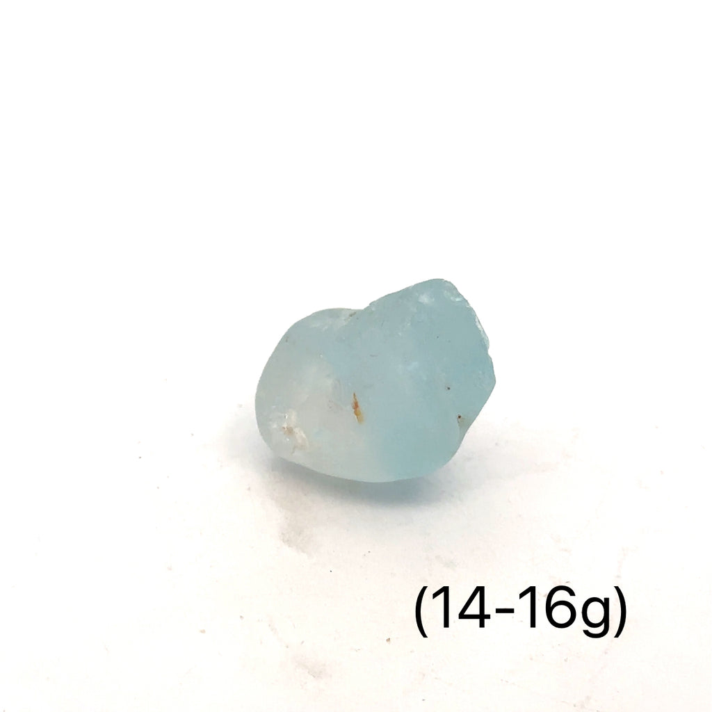 Raw Blue Topaz Gemstone on white grouping 14-16g front view 