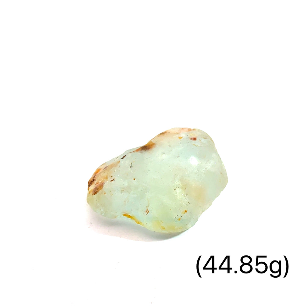 Raw Blue Topaz Gemstone on white grouping 44.85g close up front view 
