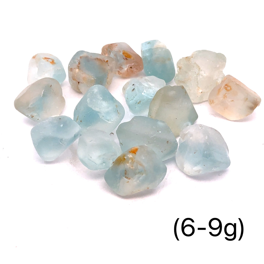 Raw Blue Topaz Gemstone on white grouping 6-9g front view 