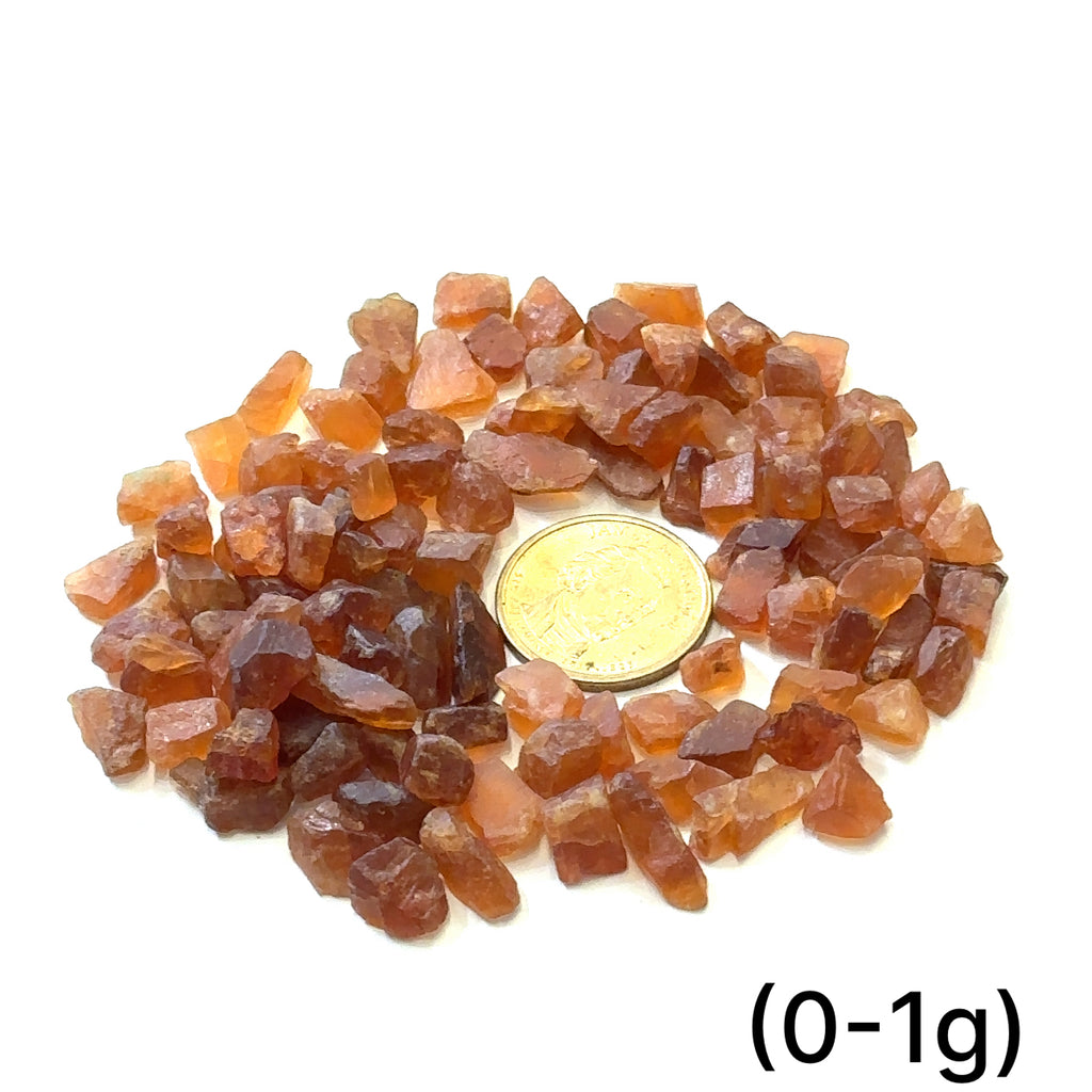 Raw Spessartine Garnet Gemstone grouping (0-1g) on white center overview