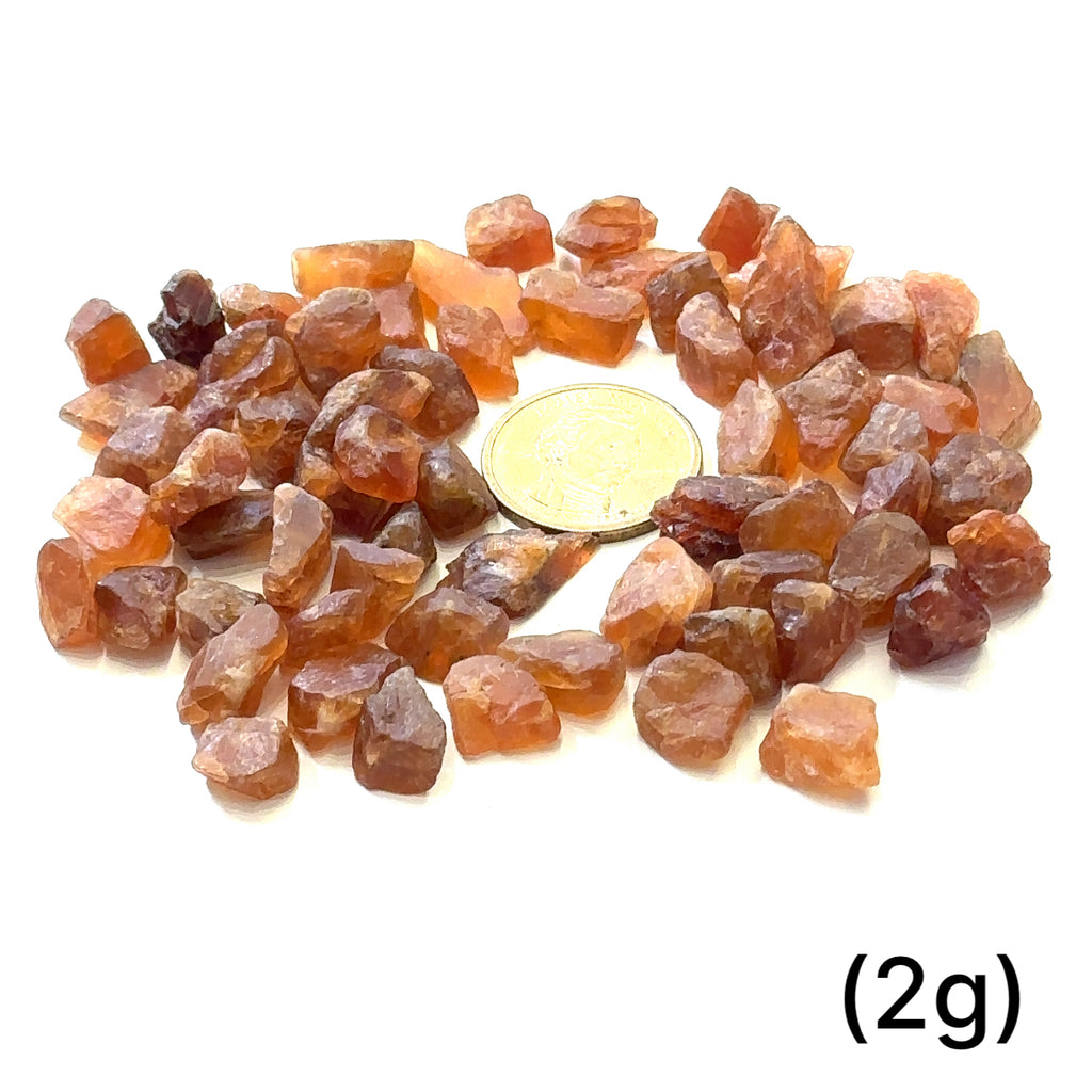 Raw Spessartine Garnet Gemstone grouping (2g) on white center overview