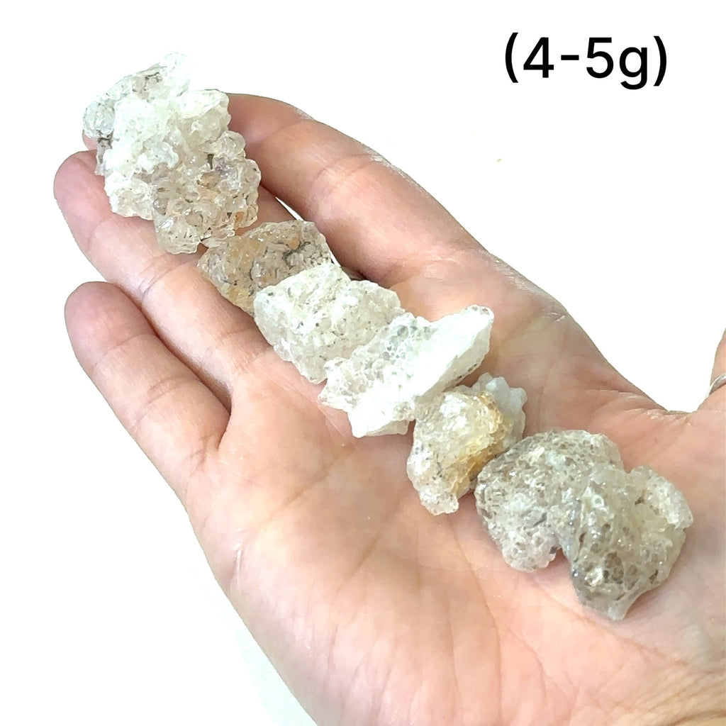 Raw opal stone for Crown and Third Eye chakra alignment grouping of (4-5g) on white in hand for overview
