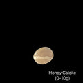 Reiki-charged Honey Calcite crystal for mental clarity and confidence, on a black background, (0-10g) front view.