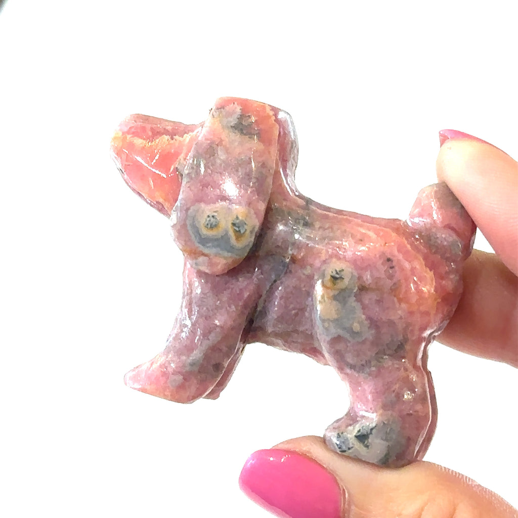 Rhodochrosite carving for emotional healing and heart chakra balance on white right side in hand view