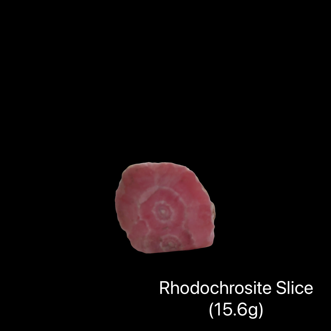 Rhodochrosite slice on a black background with weight indication (15.6g), front view.