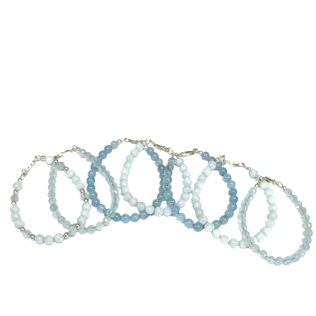 Set of five Aquamarine gemstone beaded bracelets in various shades of blue on a white background front overview. 