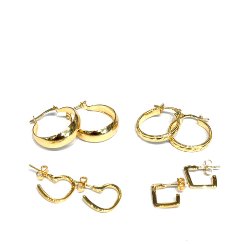 Set of four different gold hoop earrings on a white background, front overview. 