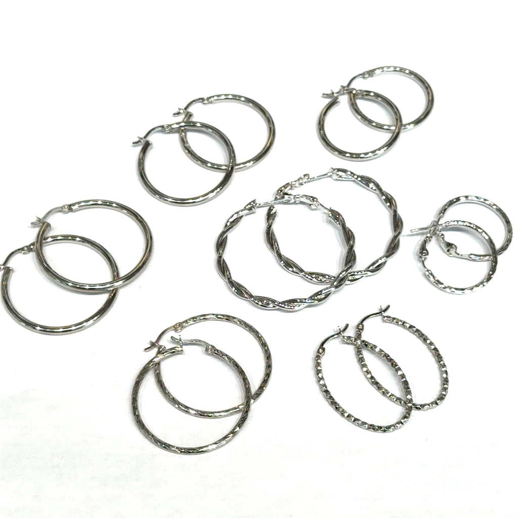 Seven sets of silver hoop earrings on a white background, front overview.