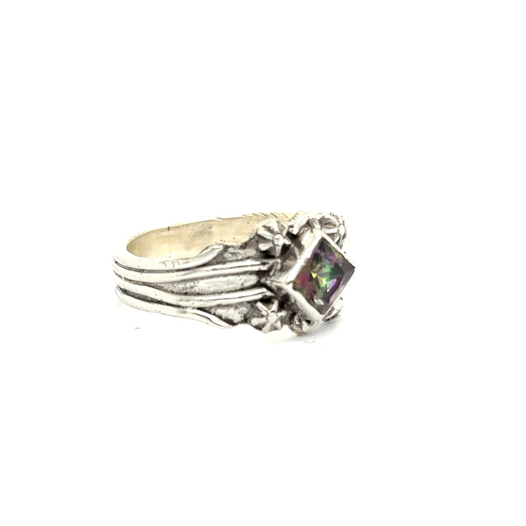 Side view of handcrafted sterling silver band with decorative top on white left angle view