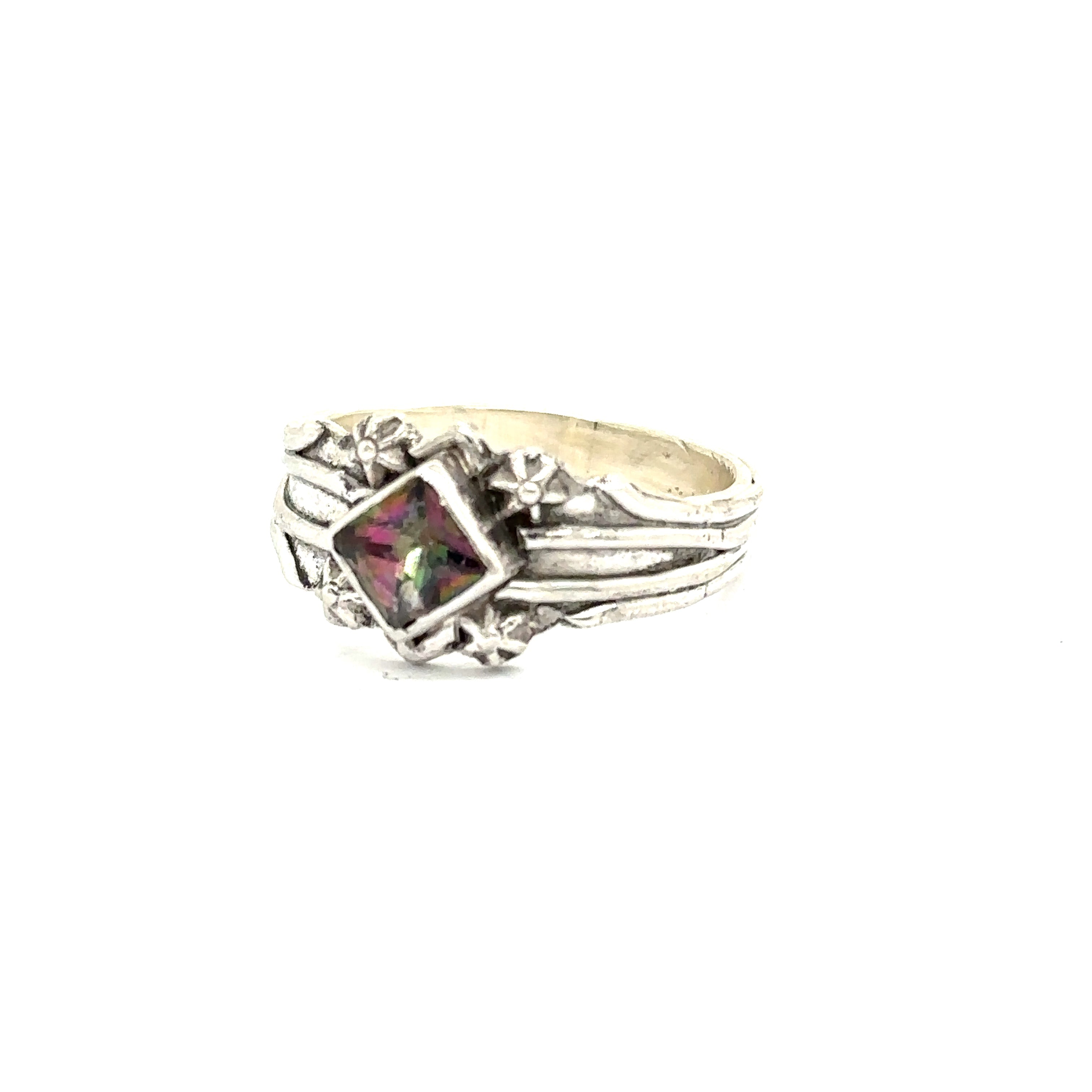 Side view of handcrafted sterling silver band with decorative top on white right angle view