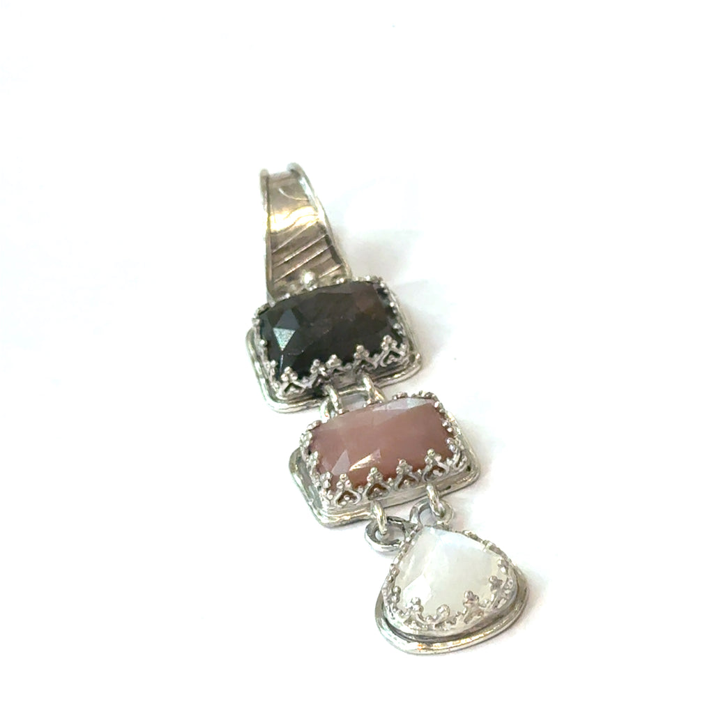 Silver pendant with three gemstones (labradorite, peach moonstone, and rainbow moonstone) on a white background, front view. 