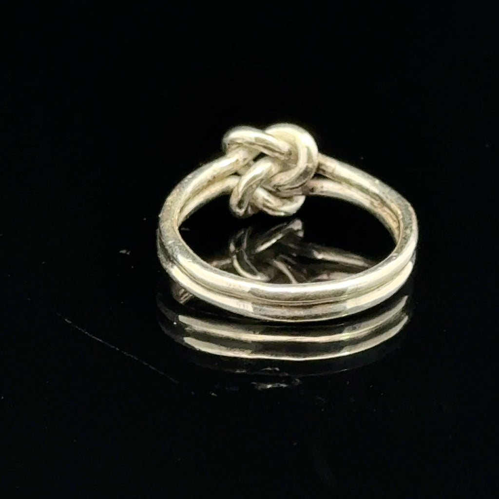 Sterling silver double knot ring handcrafted by Ivy Rose on a black background back side, close up overview. 