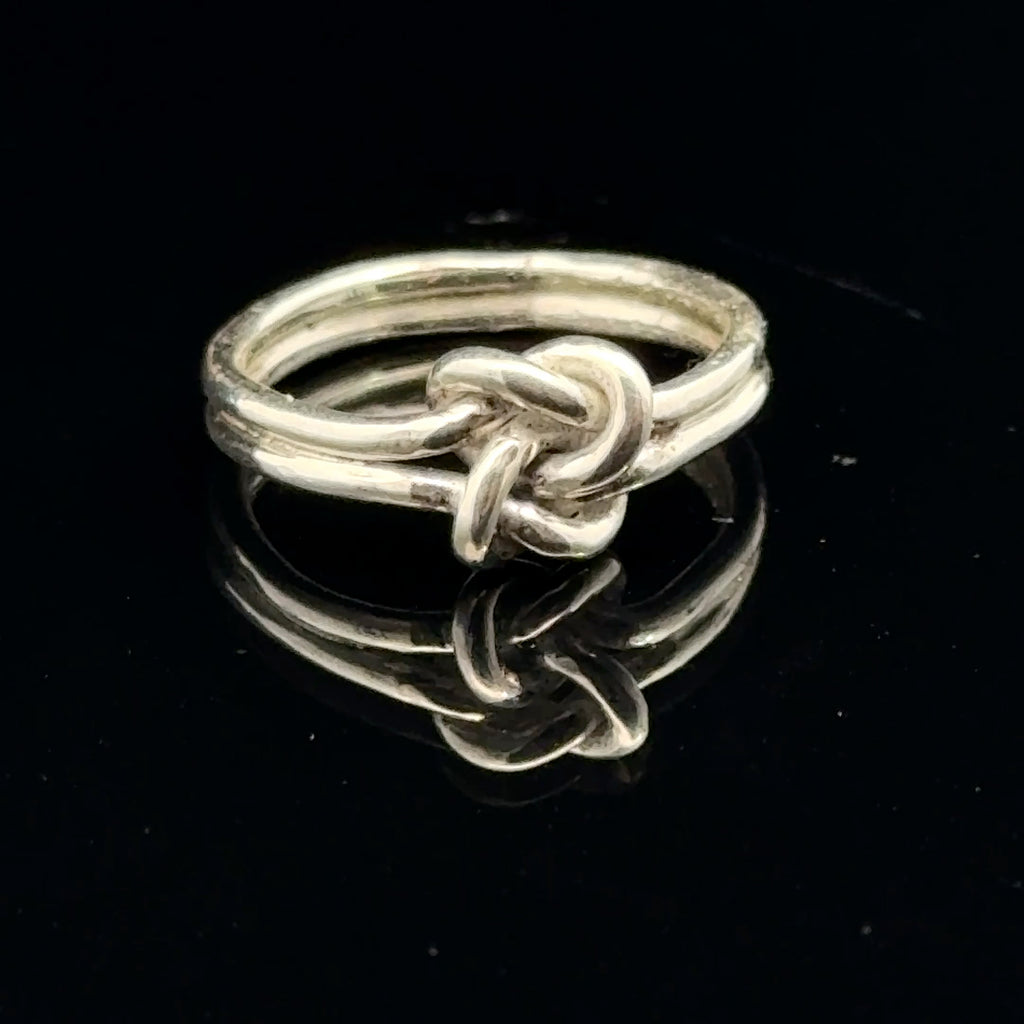 Sterling silver double knot ring handcrafted by Ivy Rose on a black background front overview. 