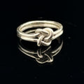 Sterling silver double knot ring handcrafted by Ivy Rose on a black background front overview. 