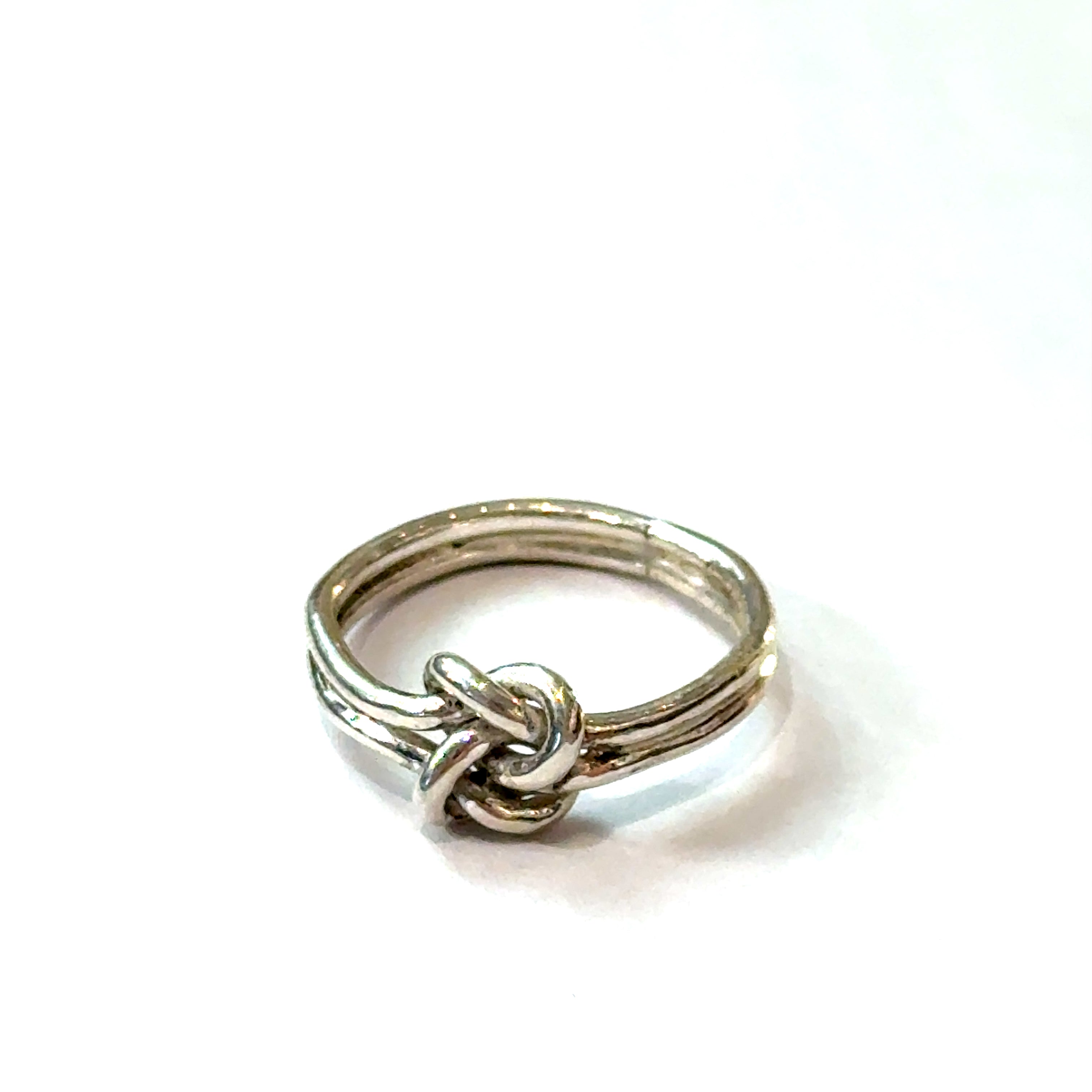 Sterling silver double knot ring handcrafted by Ivy Rose on a white background  front, close up overview. 