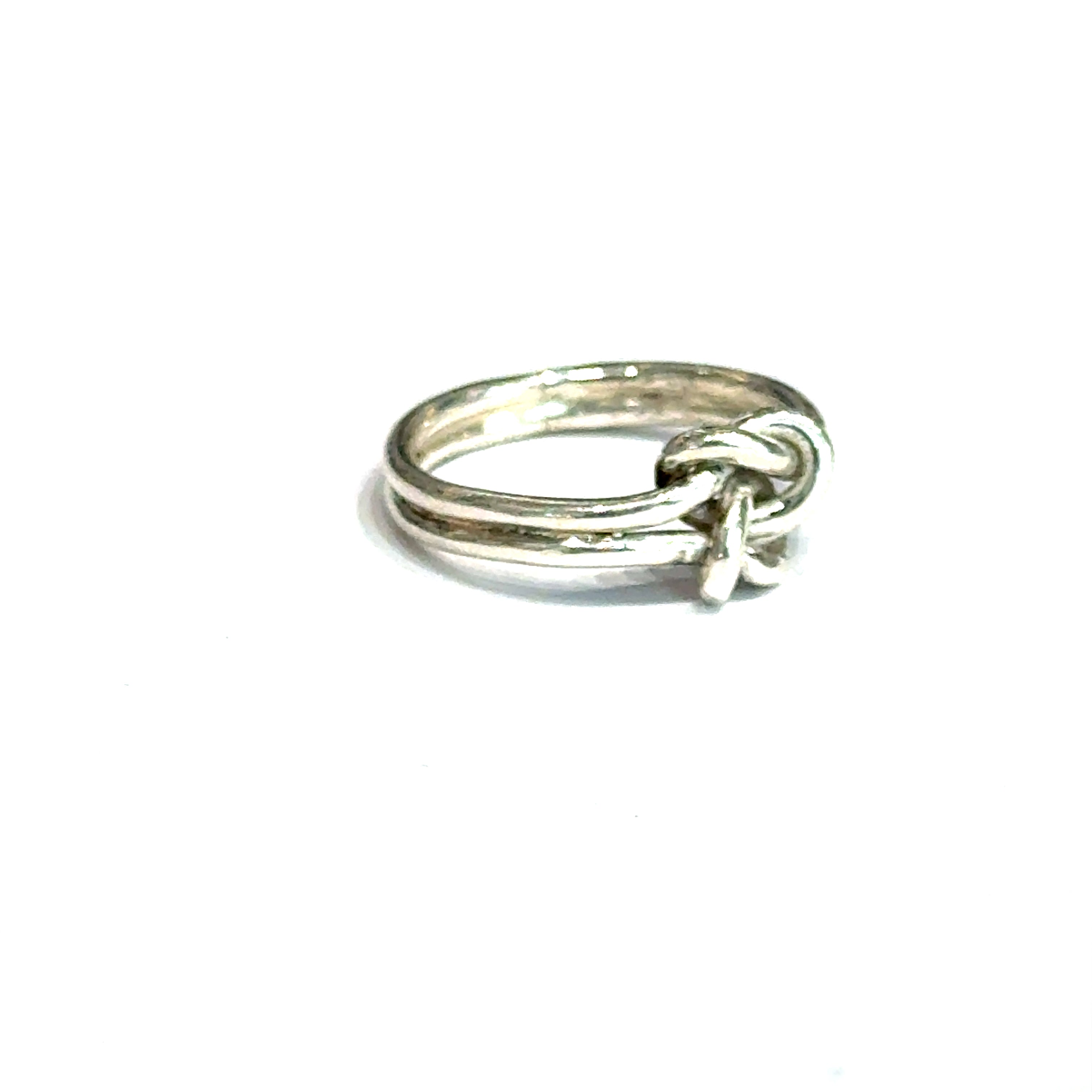 Sterling silver double knot ring handcrafted by Ivy Rose on a white background  slight right angle, close up overview. 