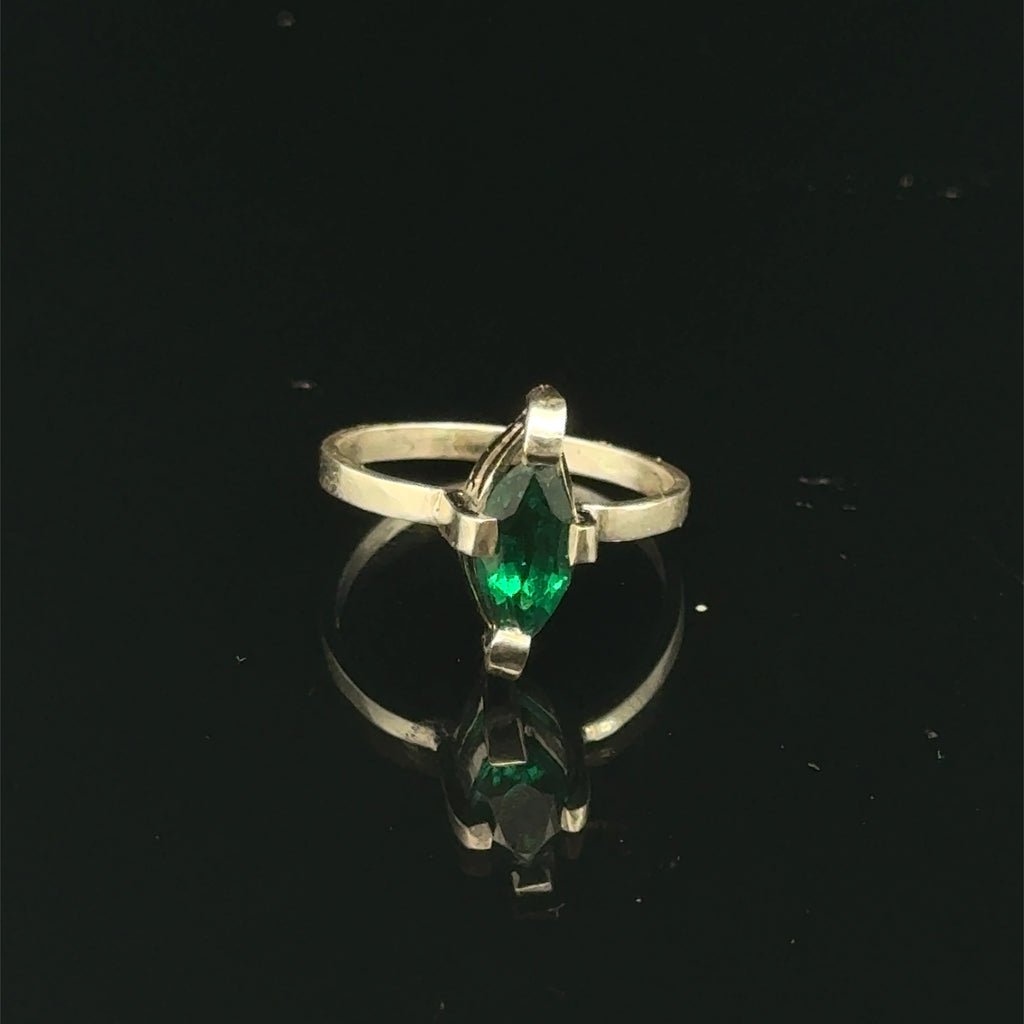 Sterling silver ring with faceted marquis emerald gemstone on a black background front, close up  view.