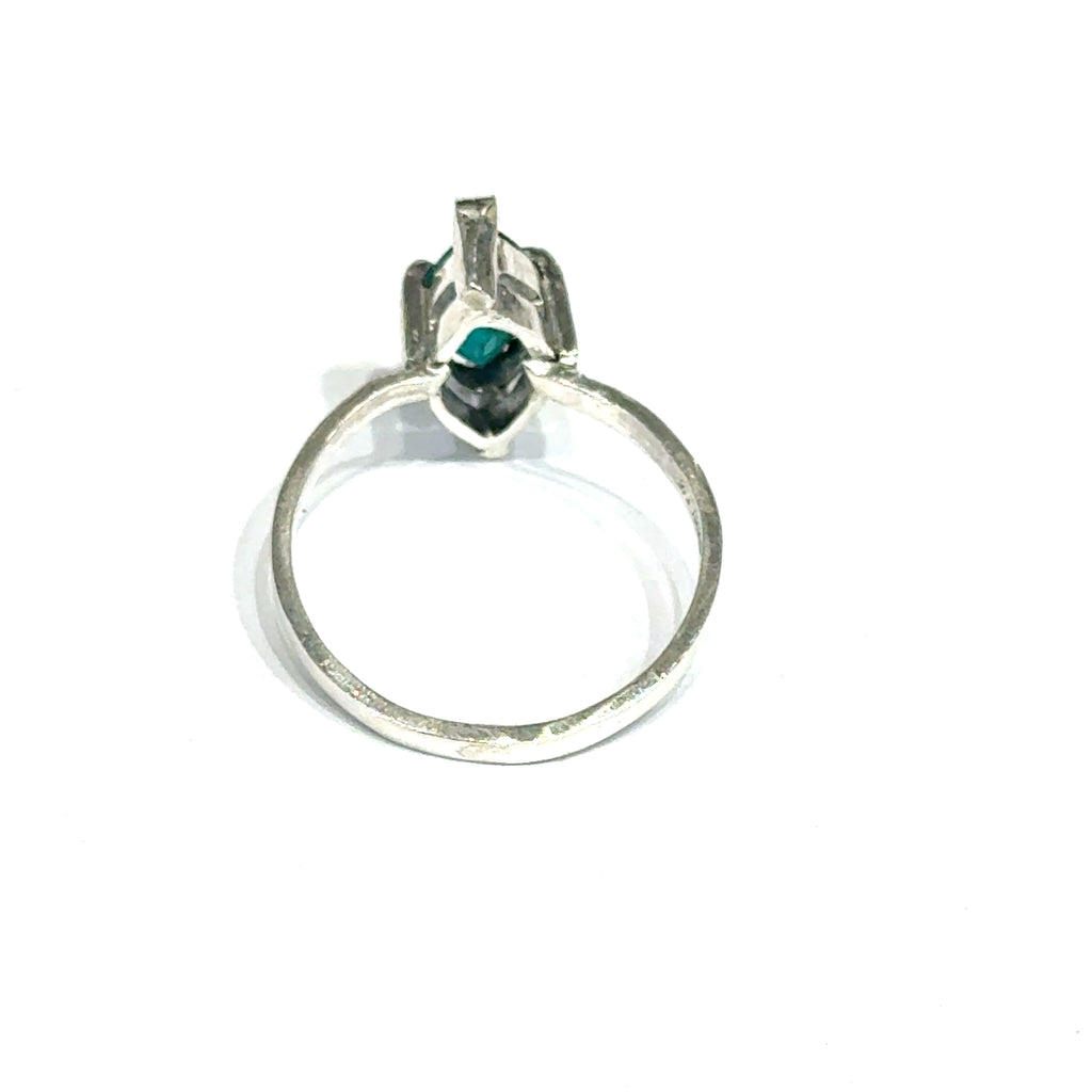Sterling silver ring with faceted marquis emerald gemstone on a white background back, close up  view.