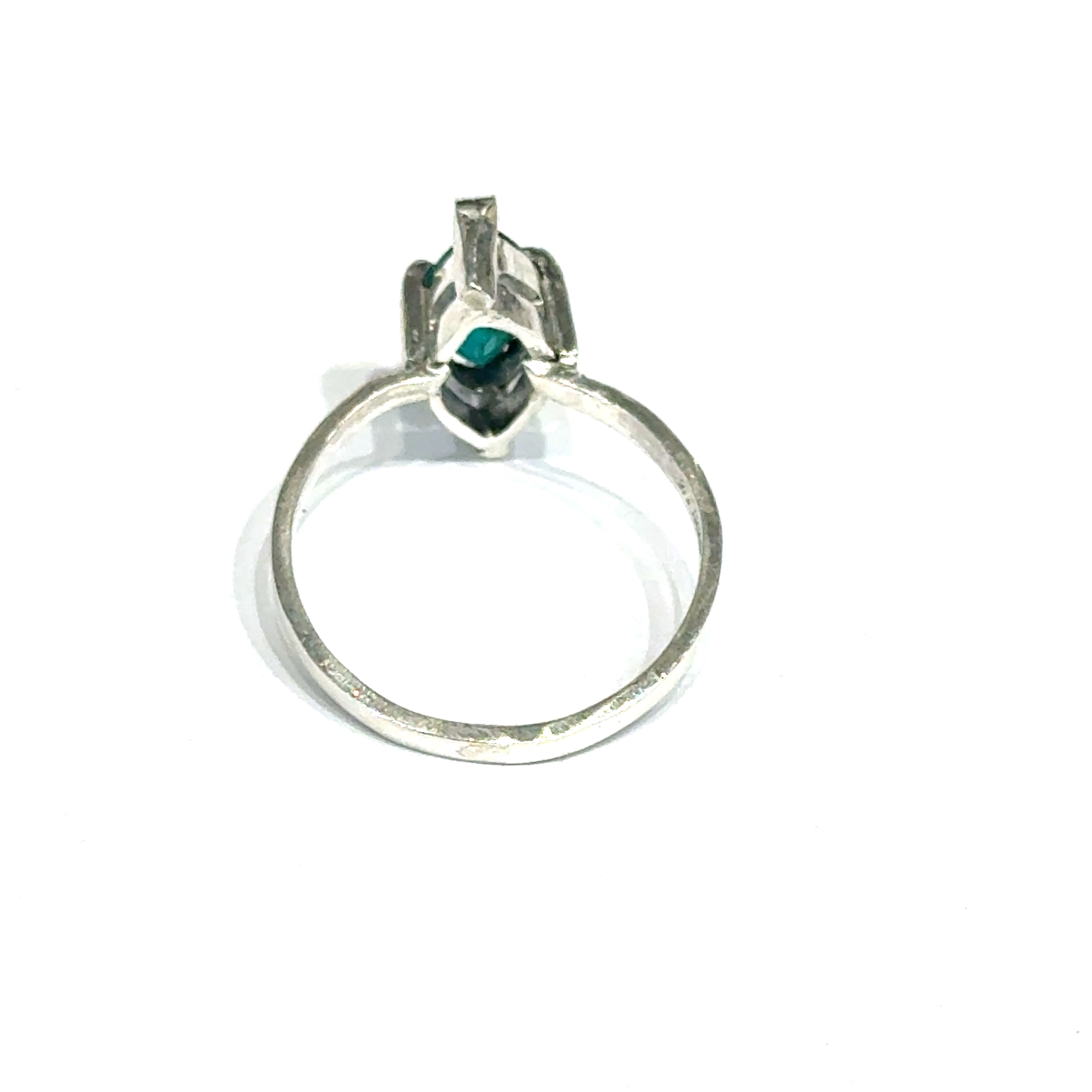 Sterling silver ring with faceted marquis emerald gemstone on a white background back, close up  view.