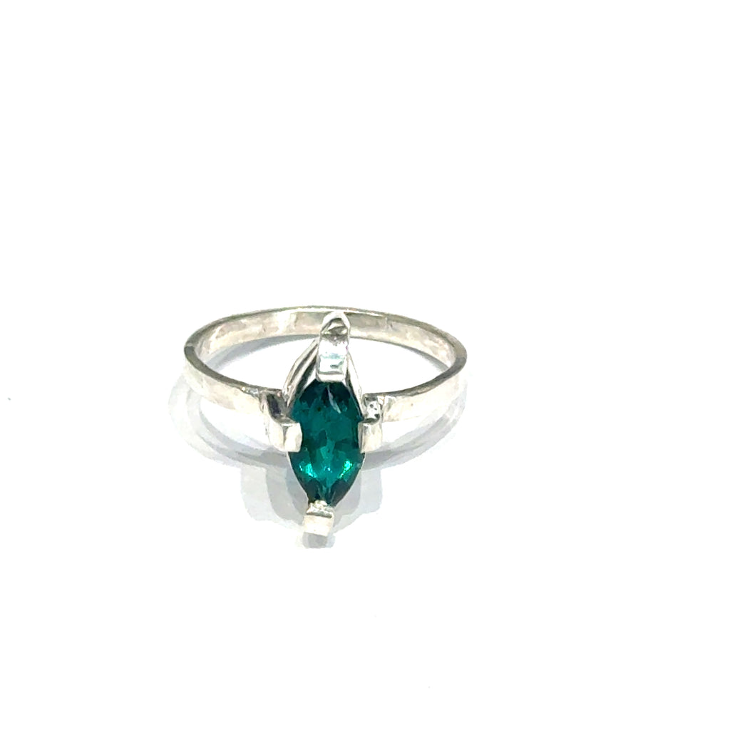 Sterling silver ring with faceted marquis emerald gemstone on a white background front, close up view.